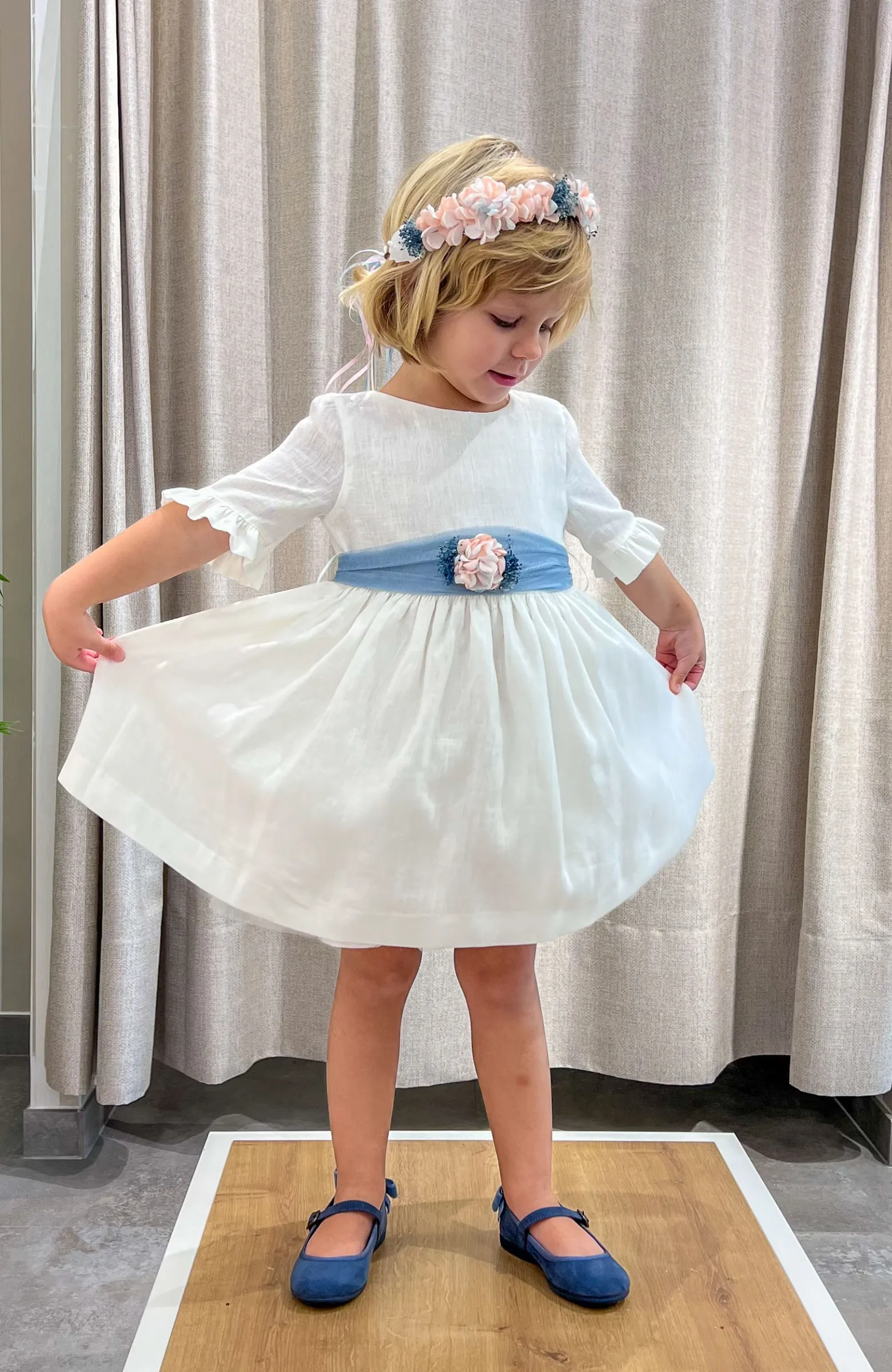 Vestido niña Arras lino con fajín azul y detalle floral, ideal para ceremonia infantil