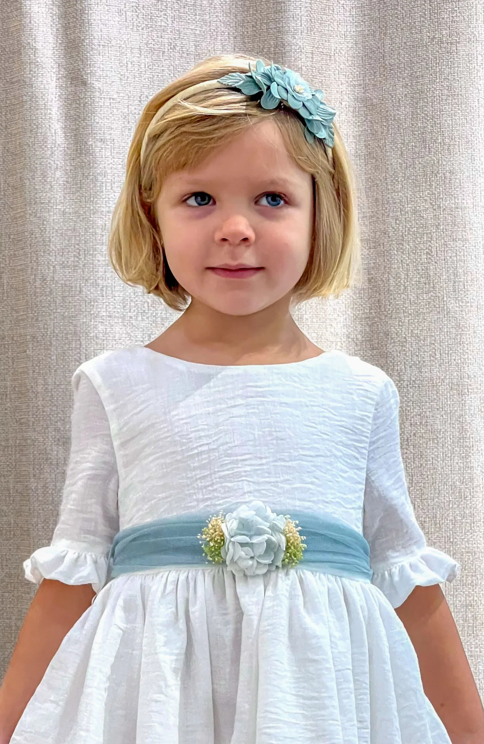 Vestido niña Arras manga francesa fajín verde sobre un fondo color crudo